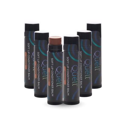 Six lip balm tubes with DermaQuell Soft Lip Conditioner Balm Cinnamon branding with cap removed on one tube revealing a brown toned lip balm