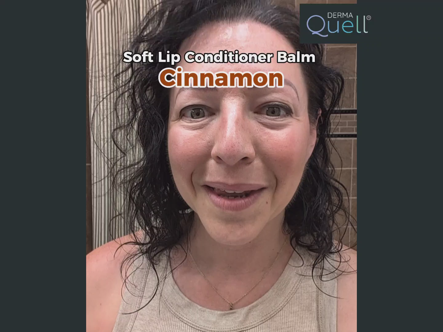 Load video: Woman in a bathroom with brown tile background demonstrating how to use the brown tinted DermaQuell Soft Lip Conditioner Balm, "Cinnamon".